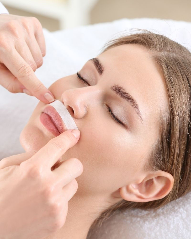 Une femme qui fait une épilation à la cire des lèvres supérieurs (bouche)