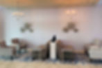 Sitting area at hotel with chairs, chandeliers and wall art