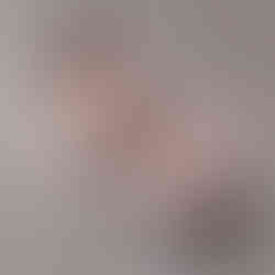 photo de nouveau-né endormi emmailloté dans un lange beige sur une couverture beige