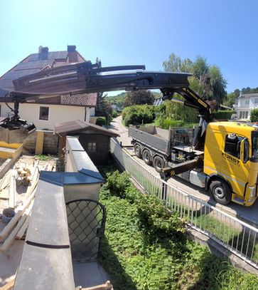 gelber LKW der Material von einer Baustelle verlädt