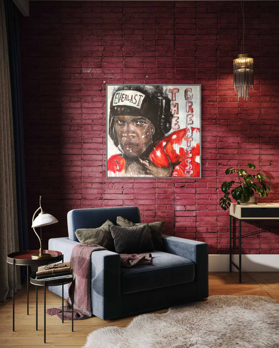 Portrait de Mohamed Ali en train de boxer avec des gants rouges sur un mur de briques