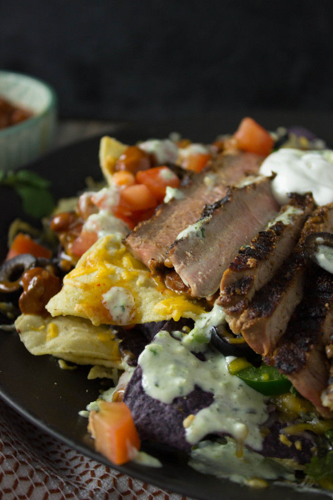 These Steak Nachos are piled high with all your favorite toppings and are easy to whip together for a yummy dinner that the whole family is going to want to dig into!