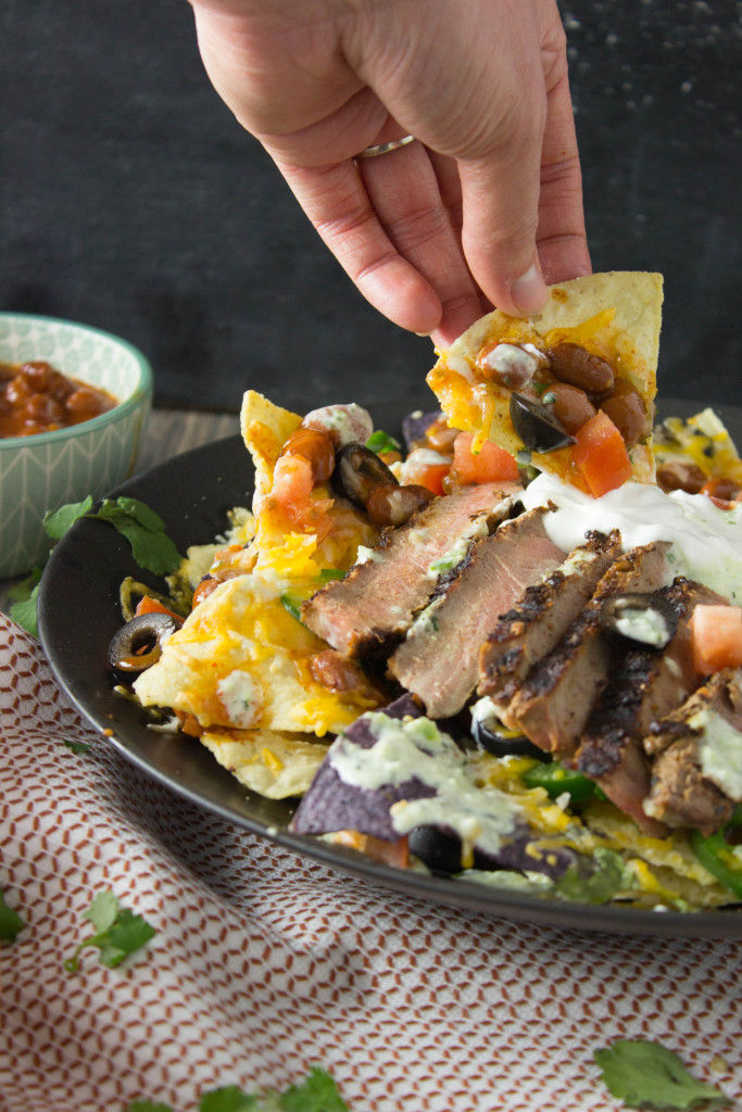 These Steak Nachos are piled high with all your favorite toppings and are easy to whip together for a yummy dinner that the whole family is going to want to dig into!