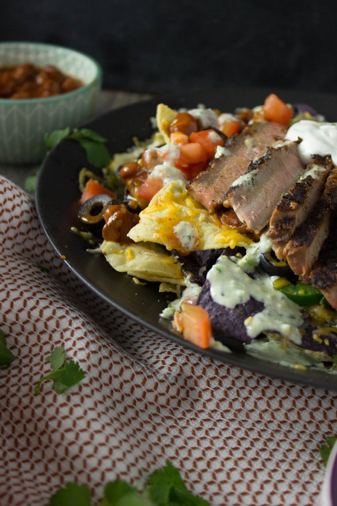 These Steak Nachos are piled high with all your favorite toppings and are easy to whip together for a yummy dinner that the whole family is going to want to dig into!