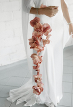Bride in white dress with long orchid floral arrangement
