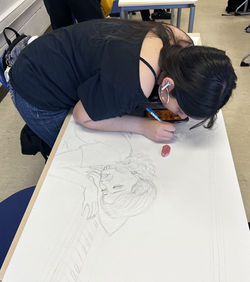 Student working on artwork for exhibit