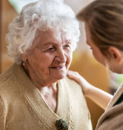 Ältere Frau im Gespräch mit einer jüngeren Person, die ihr zugewandt zuhört – symbolische Darstellung von Beratung, Beziehung und emotionaler Unterstützung.