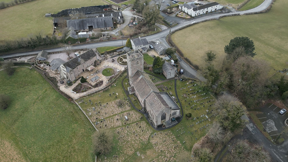View of All Hallows Church, Great Mitton, showing the church and surrounding churchyard within the village landscape.