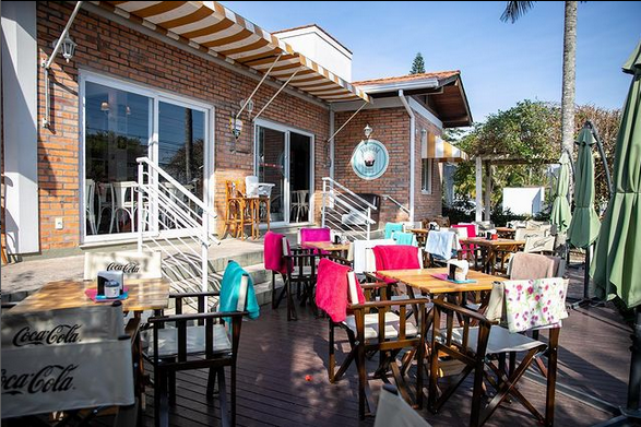 Ambiente interno do restaurante, mesas vazias em um dia de sol