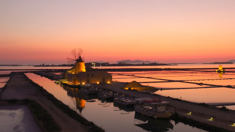 Salzmühle am Meer bei Sonnenuntergang in den Farben rot-orange
