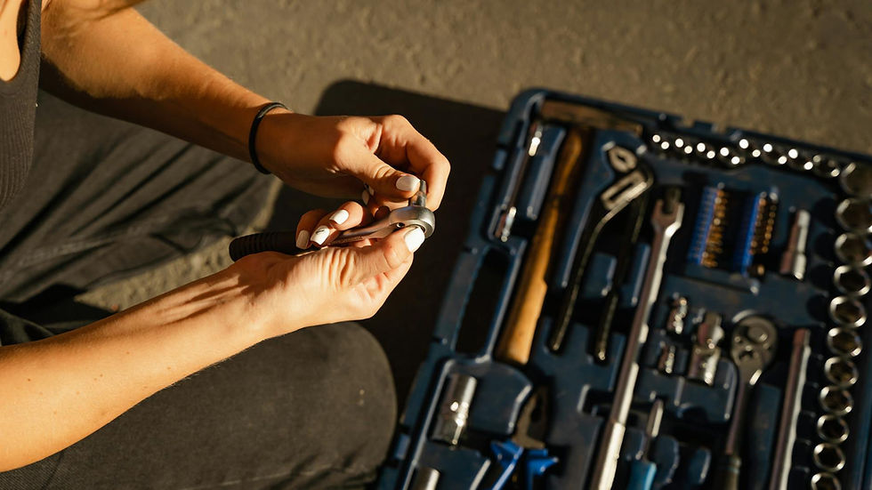 Close-up of hands using tools from a toolset in a well-lit workshop setting.