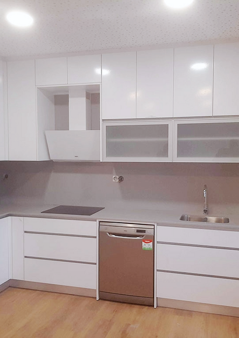 Cozinha moderna com armários brancos e eletrodomésticos de inox