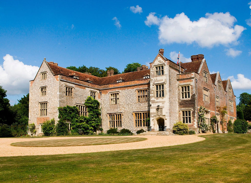 The entrance to Chawton house, a grand stone and brick house with a circular driveway.