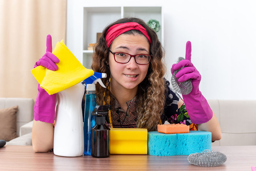 young-woman-rubber-gloves-looking-camera-smiling-showing-index-fingers-sitting-table-with-