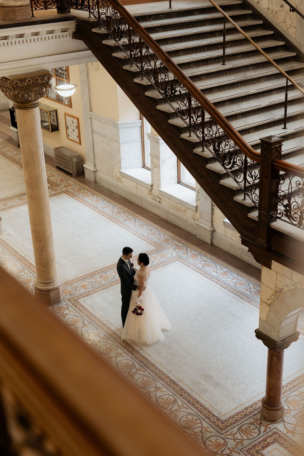 The grand staircase and marble lobby of Old City Hall, photographed from above.