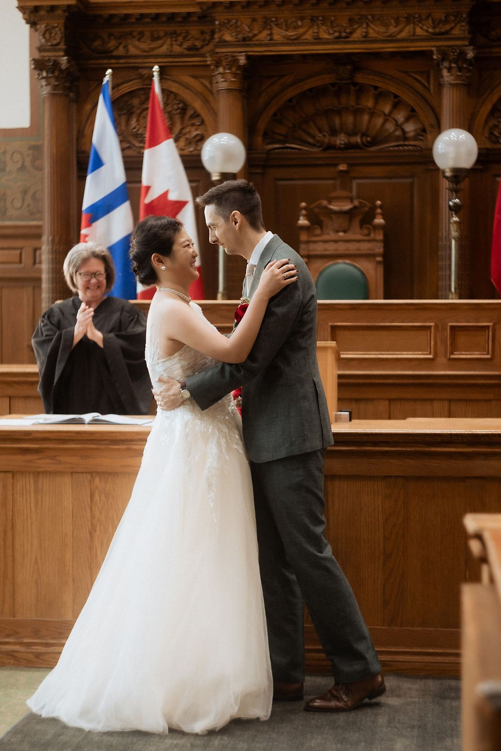 Old City Hall wedding photography in Toronto: the couple at the wooden railing of the former Council Chamber during their civil ceremony.