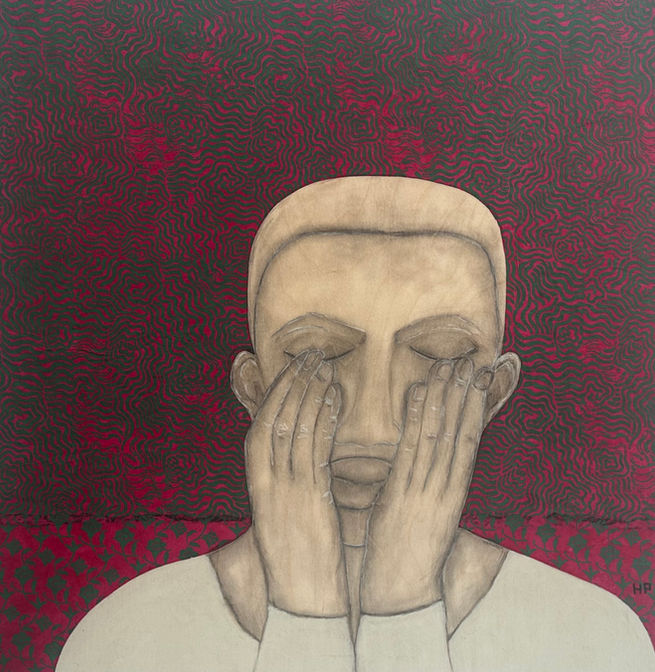 Pink and green patterned background, man seated with hands on face