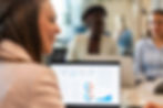 Business team reviewing performance dashboards on a laptop in a collaborative workspace, showcasing cloud data management for finance organisations.