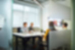 Team in a meeting room participating in a video conference, demonstrating advanced audio‑visual collaboration solutions for finance firms.