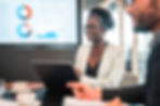 Corporate meeting with a laptop displaying analytics charts, illustrating cloud‑based productivity and workflow solutions in the financial sector.