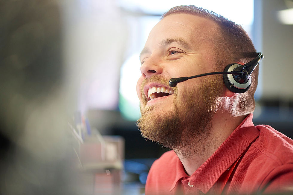IT support professional using a headset in an office environment, representing secure helpdesk operations and cybersecurity monitoring.