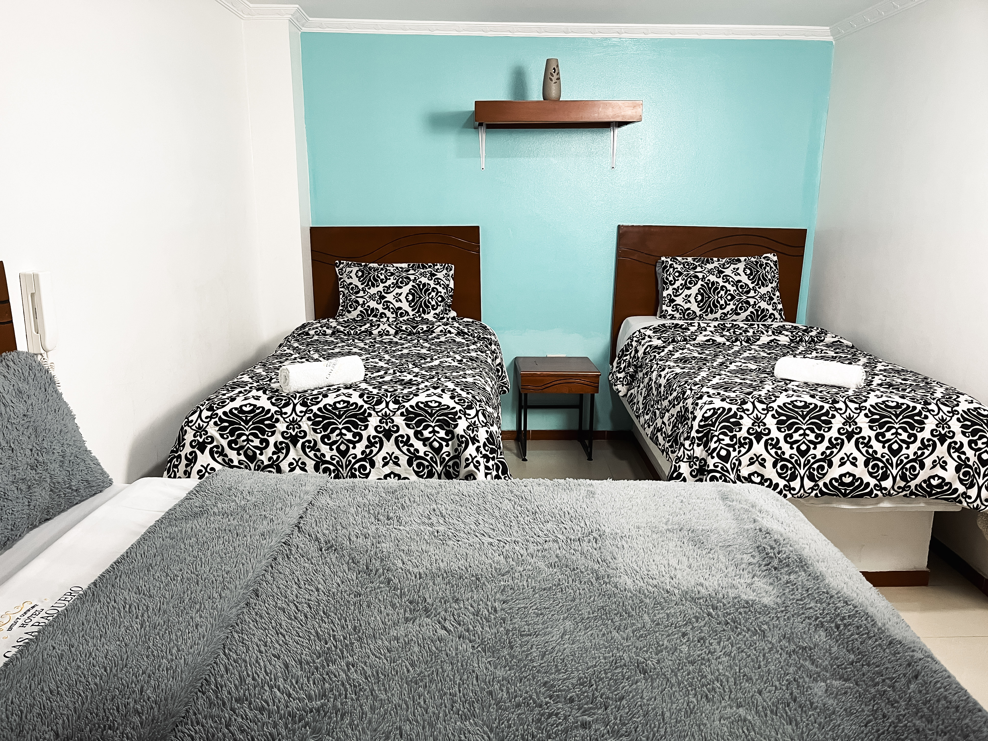 1 cama doble y 2 camas sencillas premium con lencería de lujo. Habitación familiar con servicios 24/7. ¡Tu descanso asegurado antes o después de volar!