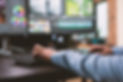 stock-photo-close-up-shot-of-digital-video-editor-sitting-at-multi-monitor-workstation-des