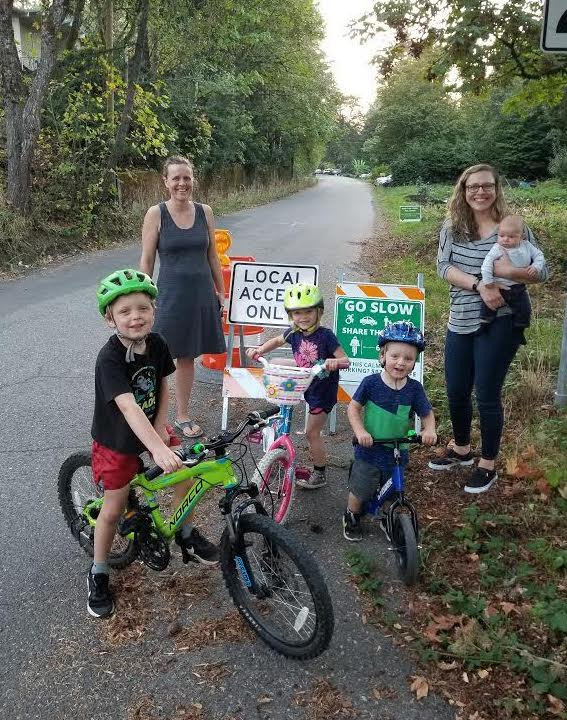 families on the street in front of Local Access Only signs.