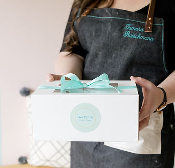 Tamara holding a cake box, ready for the customer to take home.