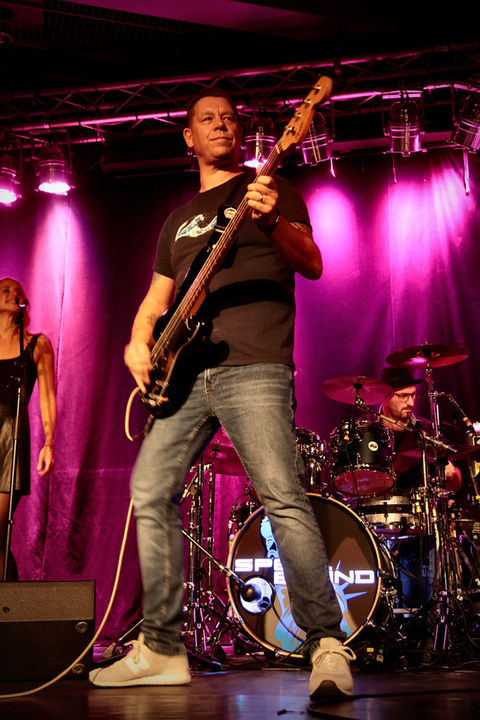 Bassist playing on stage with band