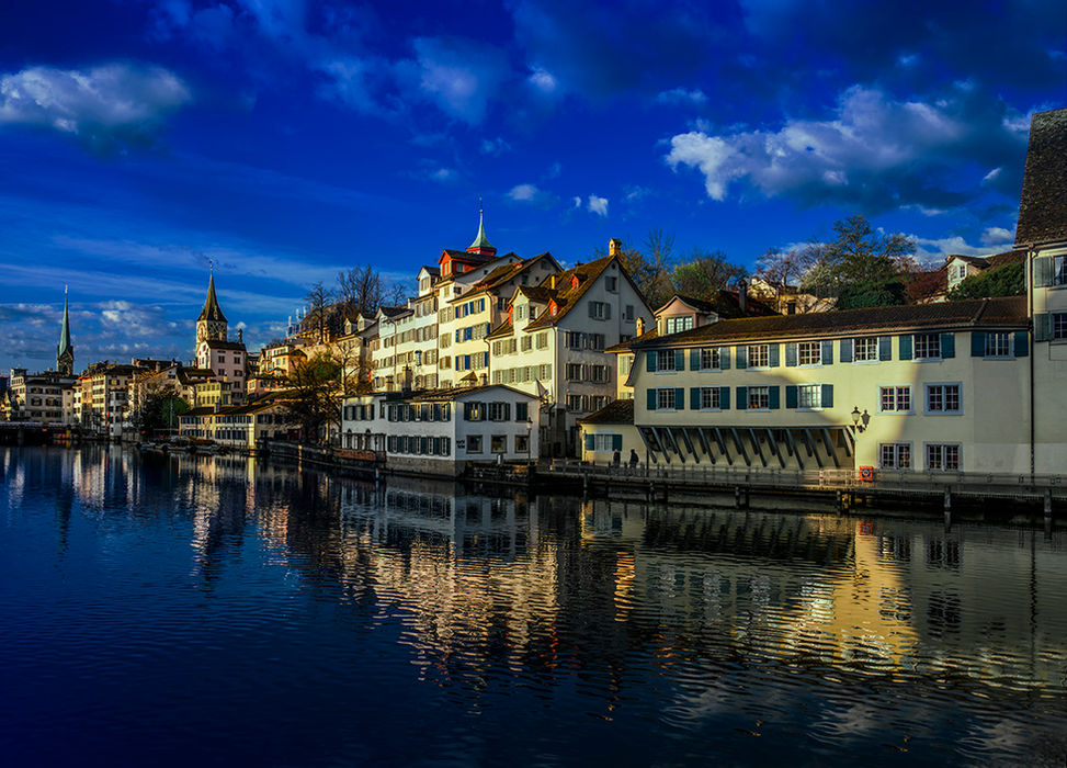 Blick über die Limmat auf die Zürcher Altstadt im Abendlicht