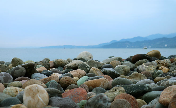pebble-stones-beach-with-blurry-seascape.jpg