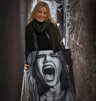 Portrett av kunstner Merete Egeland omgitt av eget maleri