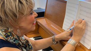 Composer at piano deciding what to write next in music composition
