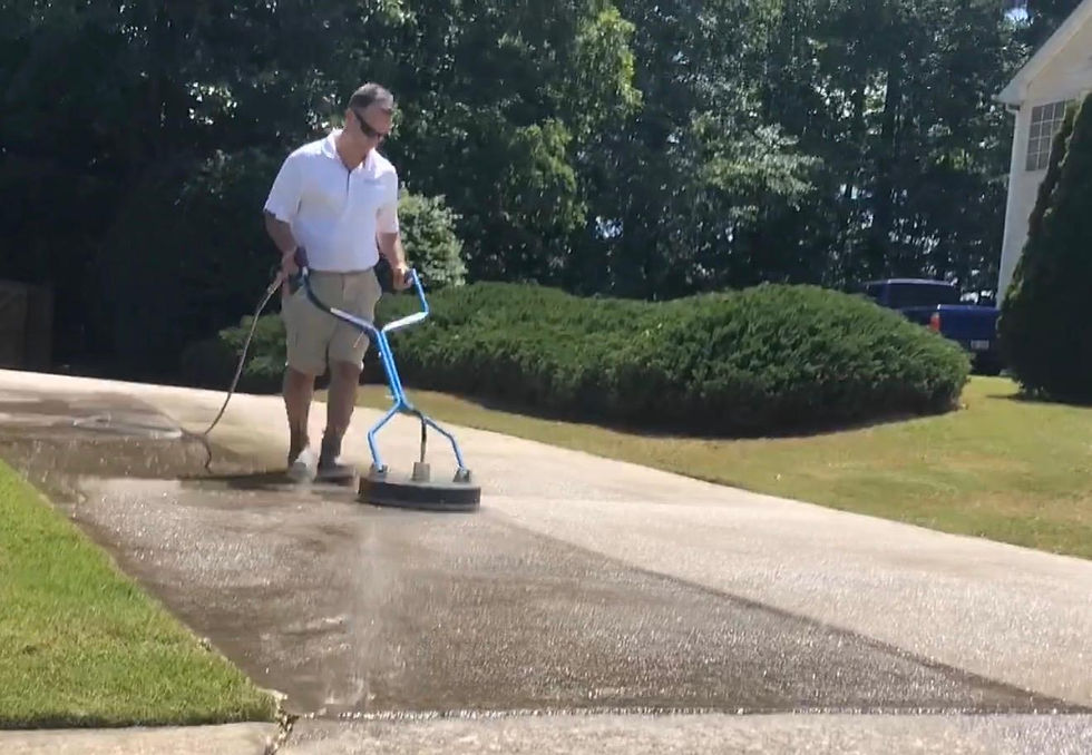Handyman services professional pressure washing a driveway.
