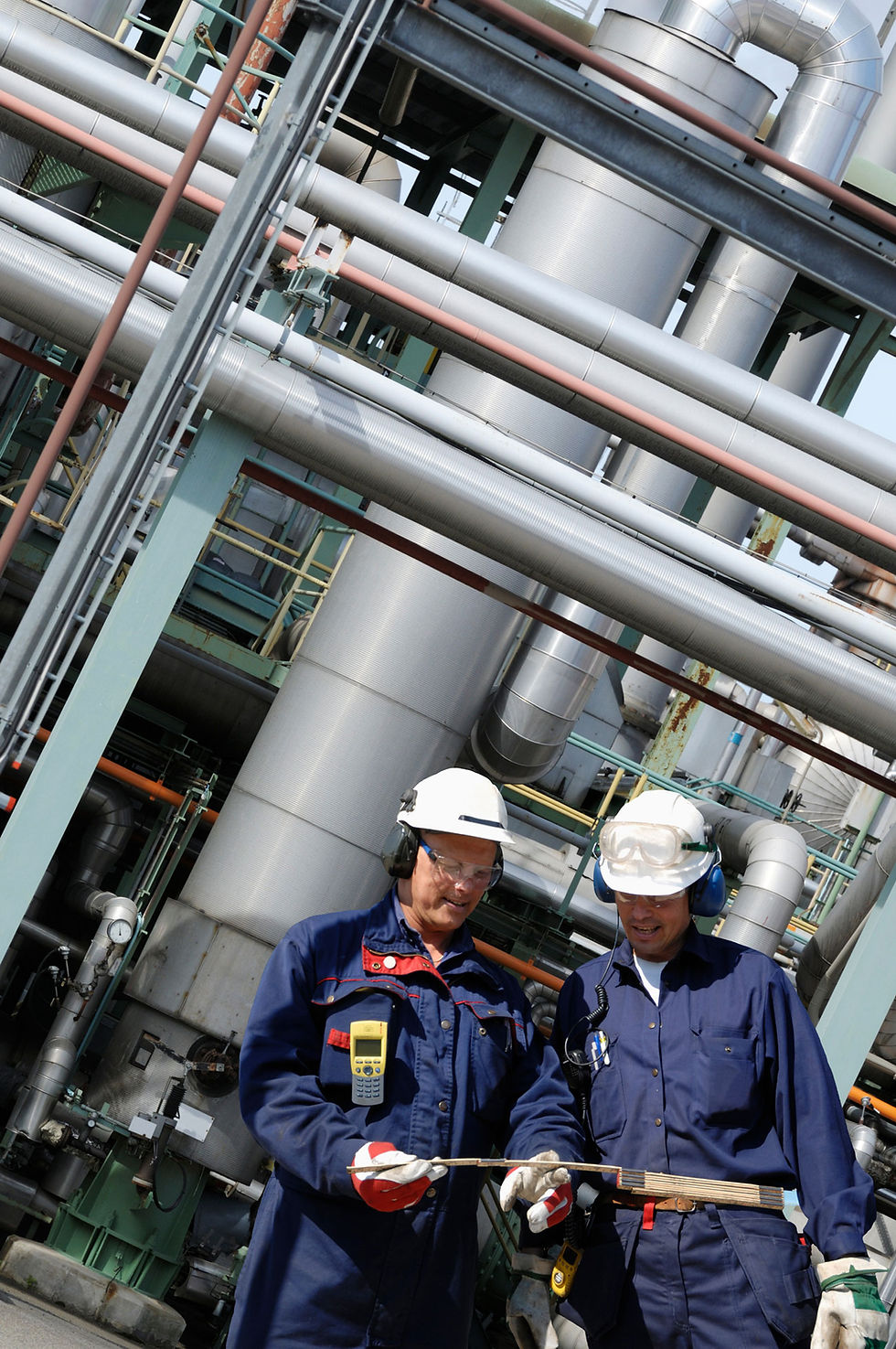 Industrial oil refinery complex with storage tanks and distillation towers, representing large-scale energy infrastructure.
