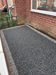 Newly installed grey resin bound pathway for home landscaping.