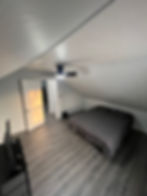 Bedroom in an affordable rental property with bed & sloped ceiling.