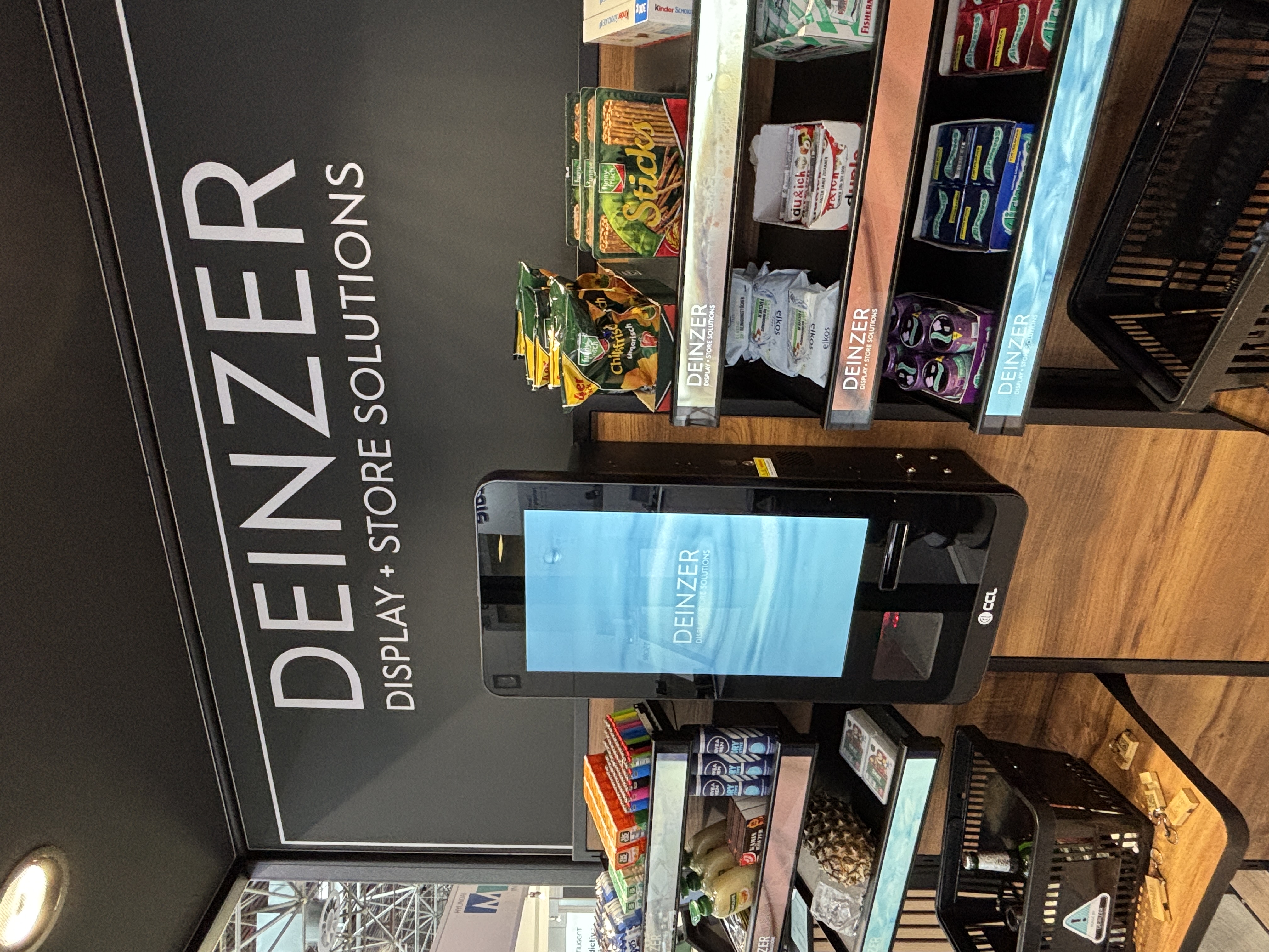 Instore-Media-Display mit integriertem Scanner und Warenpräsentation in einem Snack-Regal