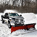 black ram with snow plow pushing snow