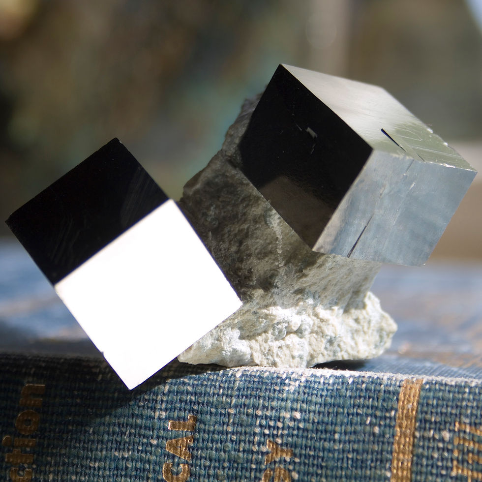 Defying gravity, this pair of beautifully balanced, tumbling crystals of lustrous cubic Pyrite live upon the Basalt matrix in