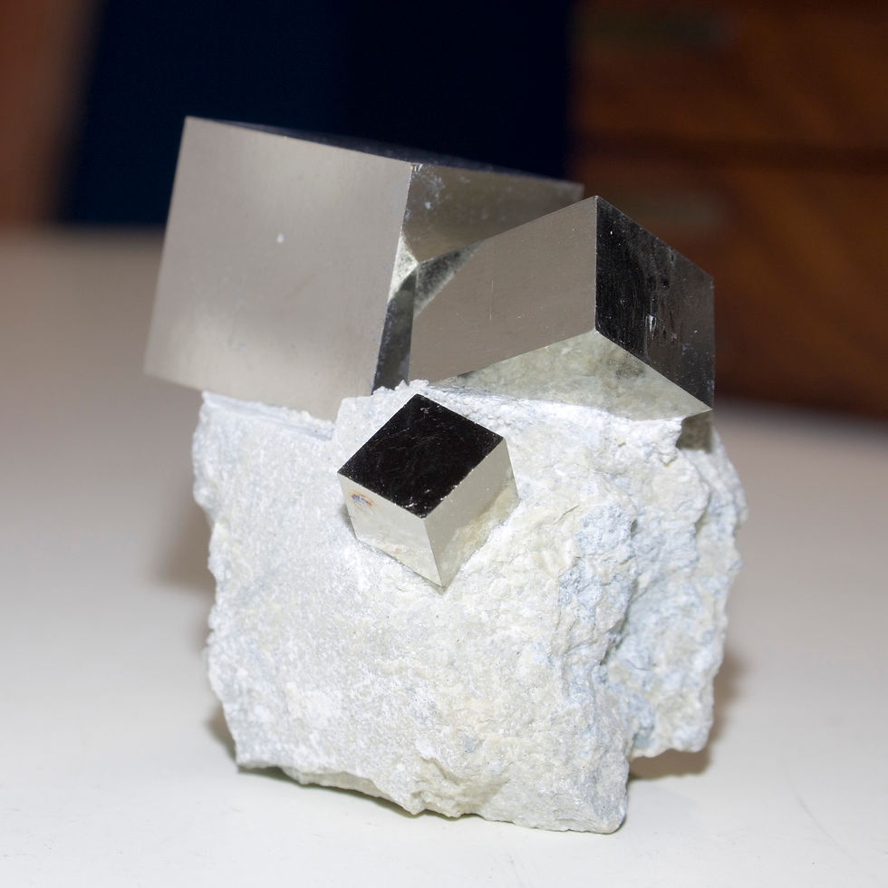 Three beautifully balanced, dramatically perched crystals of lustrous cubic Pyrite of descending size on the Marl matrix in w