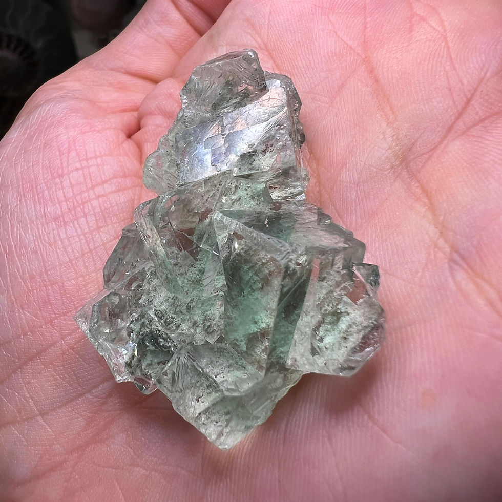 Clear green of Fluorite crystals with crisply beveled edges. Minor aspects of matrix are visible through the piece, transluce
