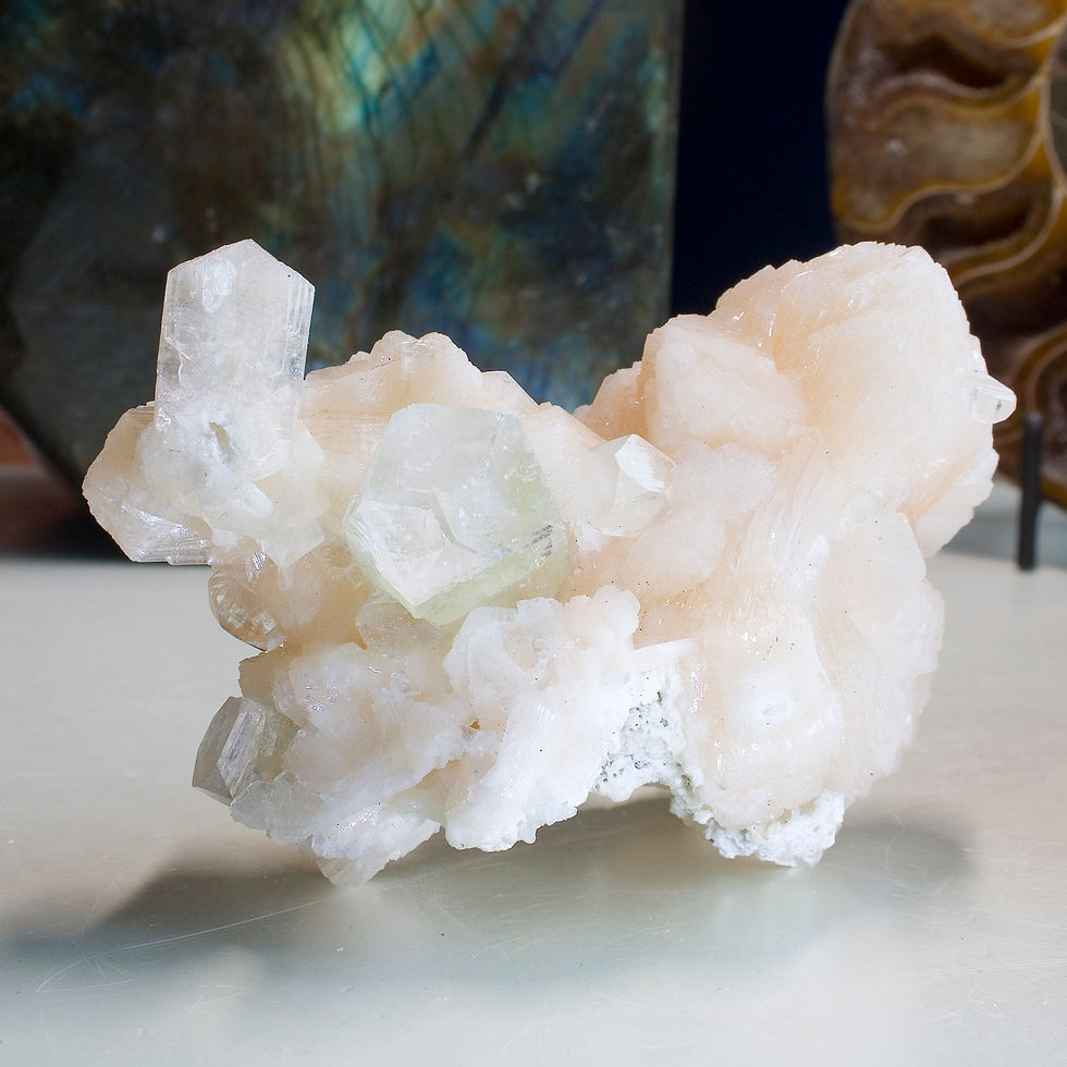 Thumbnail: A graceful cluster of pink-peach high luster Stilbite hosts a number of nicely terminated crystals of Green Apophyllite. A mi
