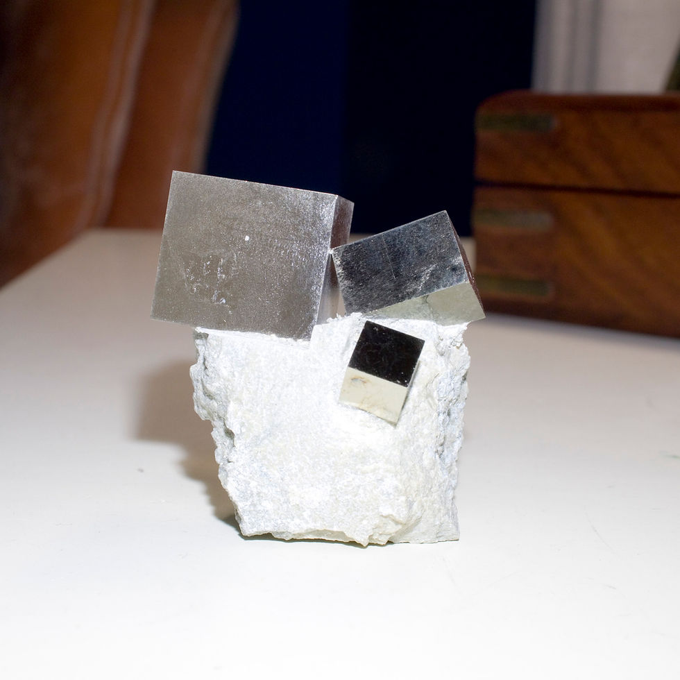 Three beautifully balanced, dramatically perched crystals of lustrous cubic Pyrite of descending size on the Marl matrix in w