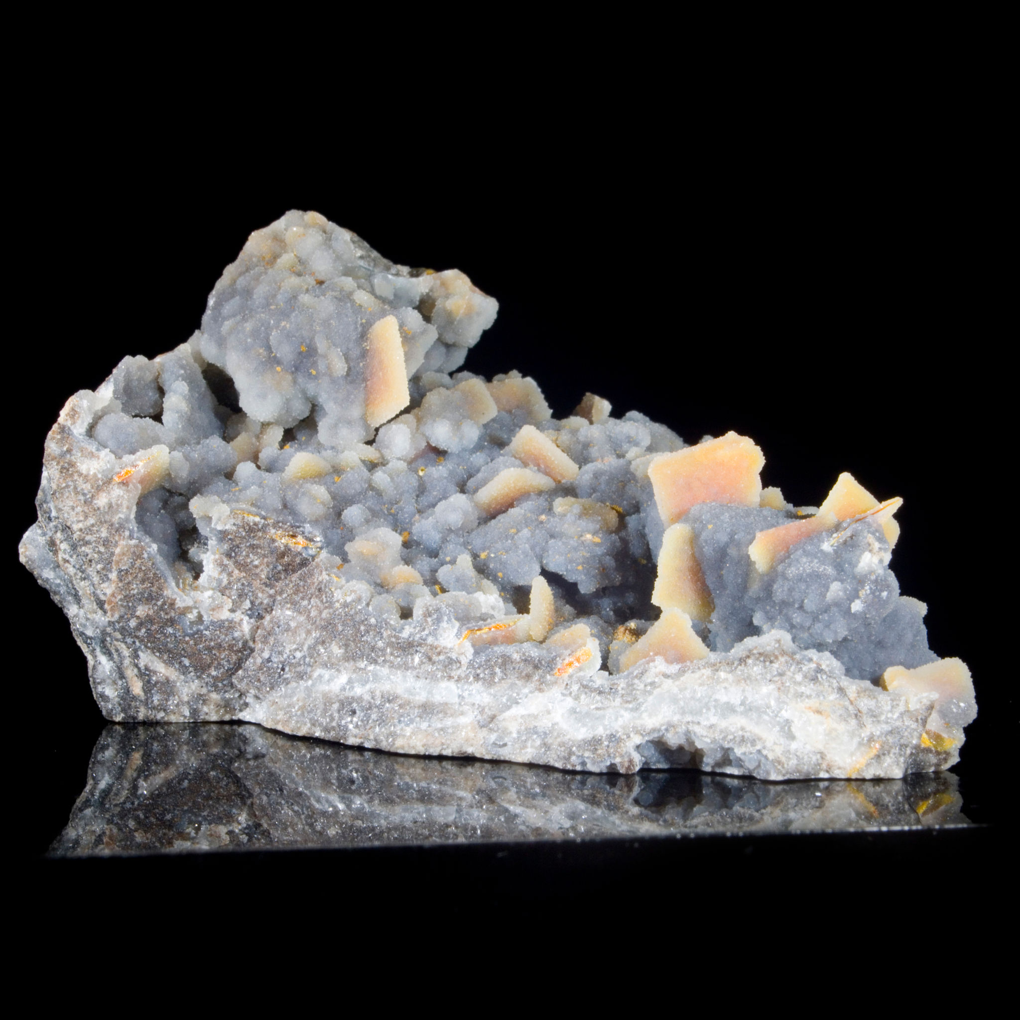 Multiple crystals of Wulfenite, coated with a thin layer of Chalcedony, on Black Chalcedony. Barking Spider Mine