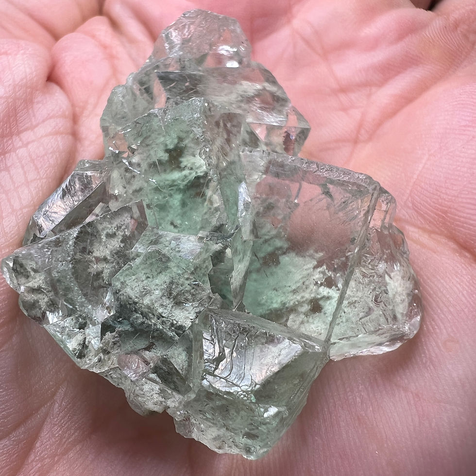 Clear green of Fluorite crystals with crisply beveled edges. Minor aspects of matrix are visible through the piece, transluce