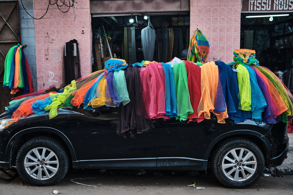 Černé auto pokryté barevným oblečením