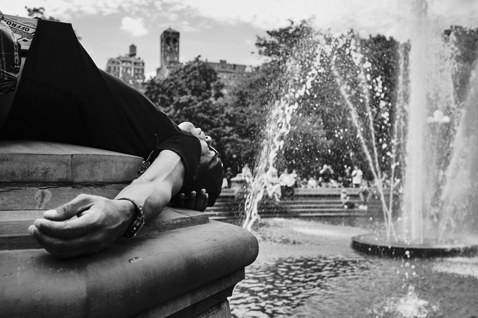 Spící muž u fontány v parku