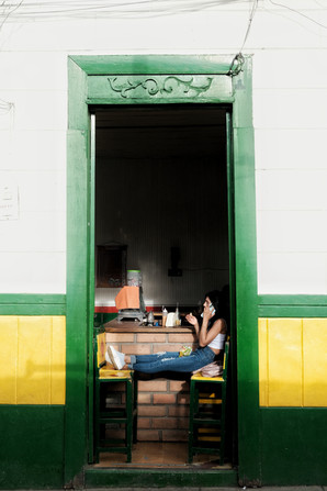 Telefonující žena s nohami na židli v obchodě